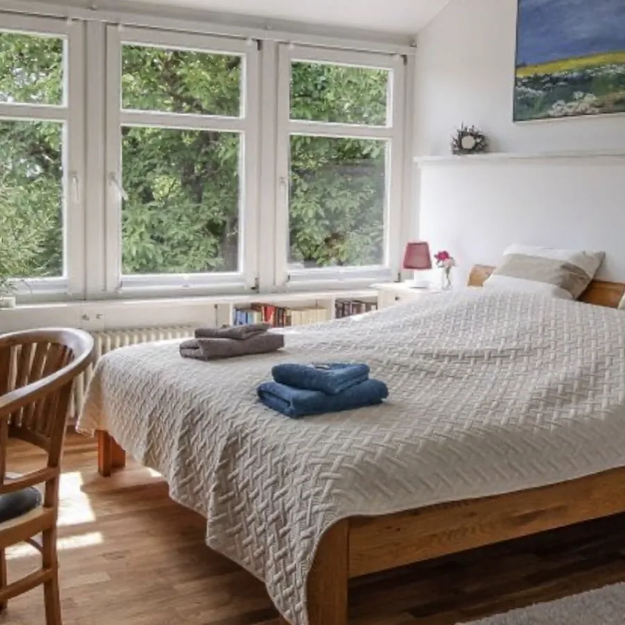 Helles Gästezimmer mit großen Fenstern